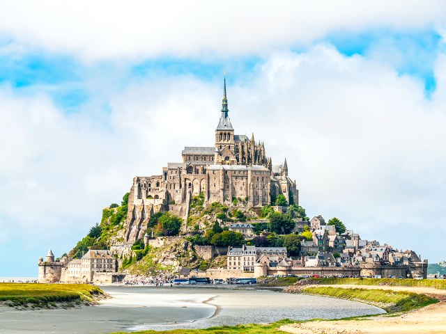 Monastery dominating the small tidal island of Mont-Saint-Michel in France, seen from shoreline