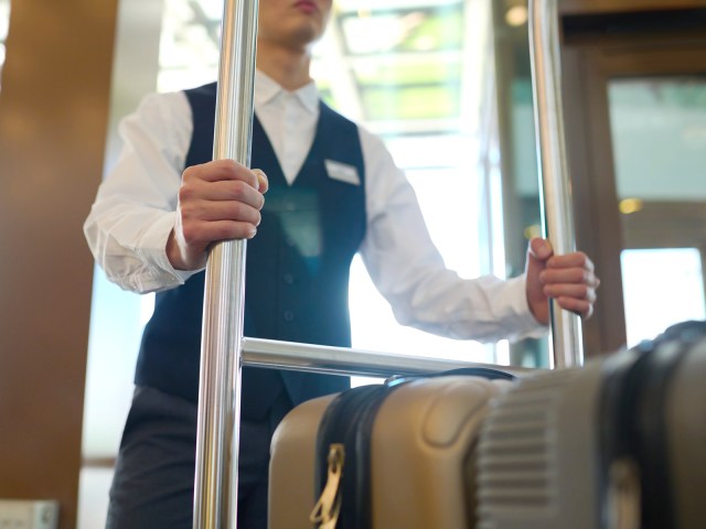 Hotel bellhop with luggage cart