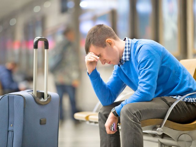 Frustrated traveler with luggage at airport