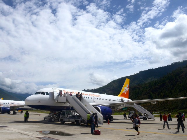 Passengers boarding aircraft via air stairs at Paro International Airport in Bhutan