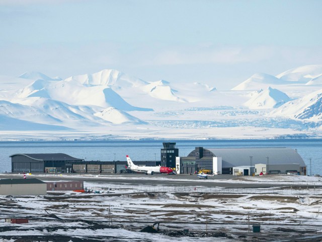 Overview of runway and terminal of Svalbard Airport in Norway, with snow-covered mountains in background