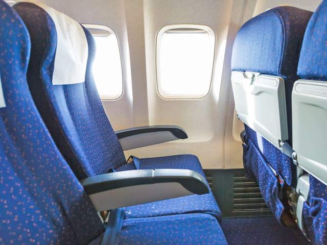Row of empty seats in economy class aircraft cabin