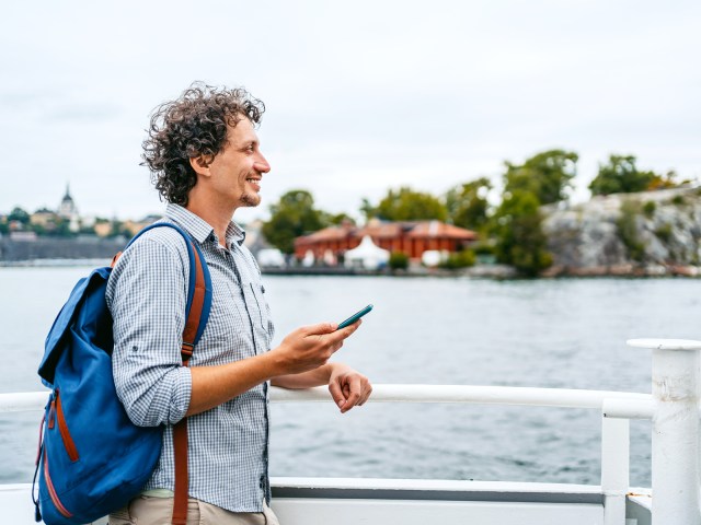 Person standing on boat with phone