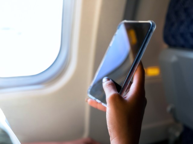 Close-up image of airline passenger holding cell phone