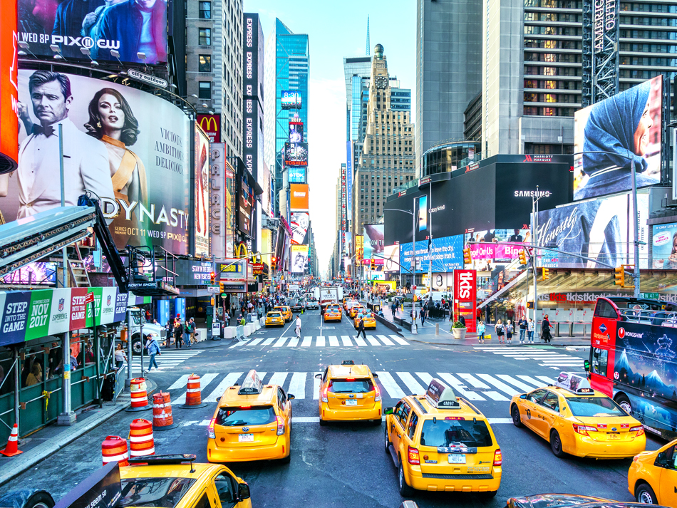 Yellow taxi cabs amid bright billboards of Times Square in New York City