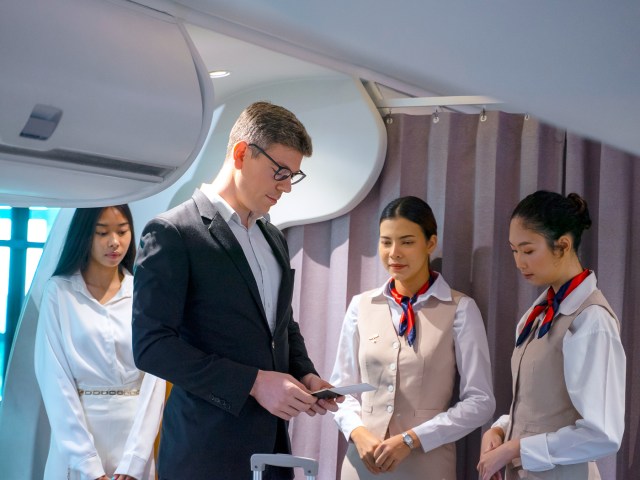 Flight attendants greeting boarding passengers