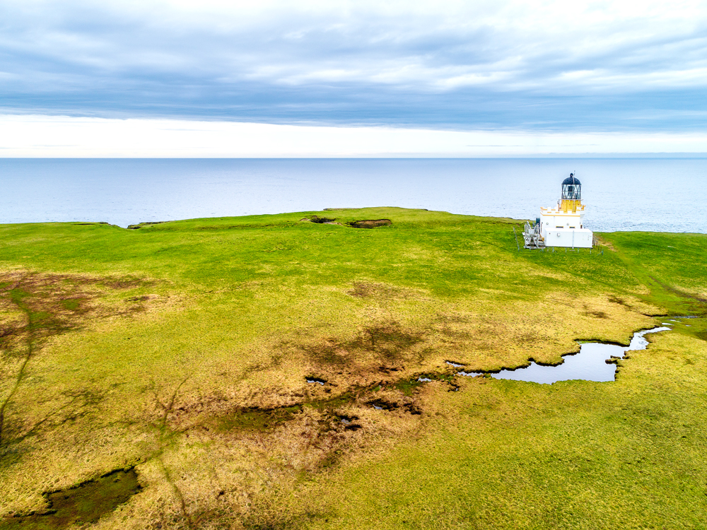 Small lighthouse overlooking coast on Brough of Birsay in Scotland
