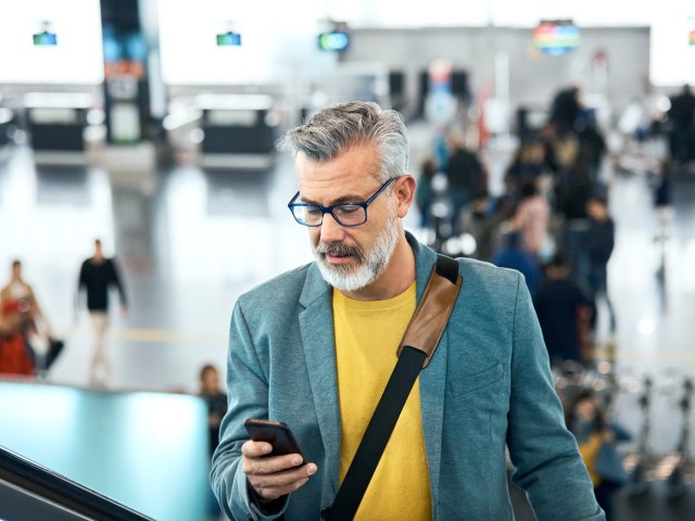 Traveler looking at phone in airport