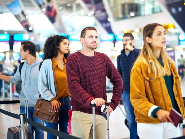 Travelers standing in airport queue