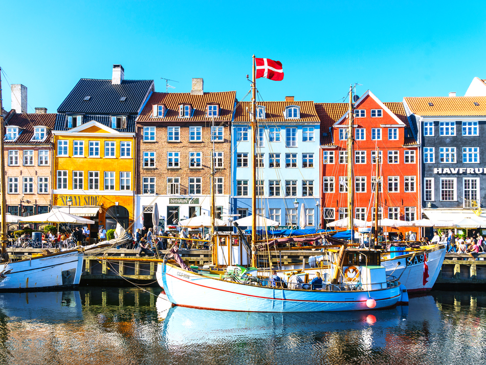 Ships docked in front of colorful row homes in Copenhagen, Denmark