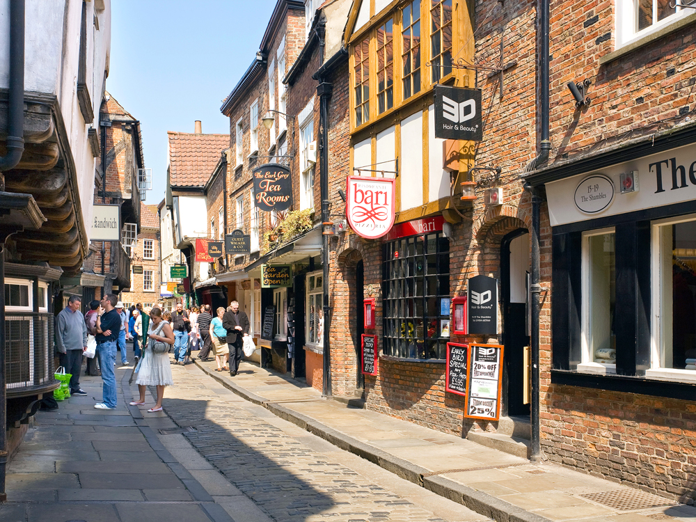 Pedestrians strolling boutiques along the Shambles in York, England