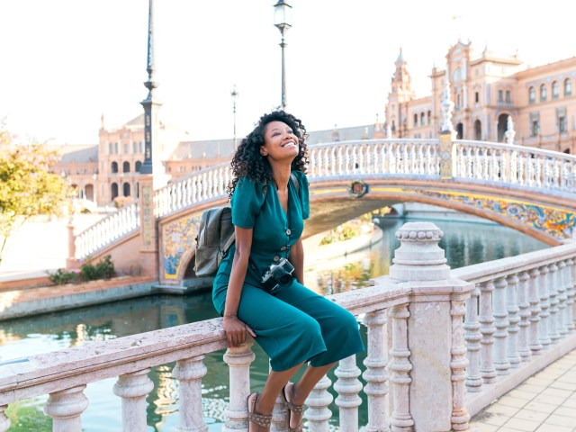 Traveler sitting on railing along river