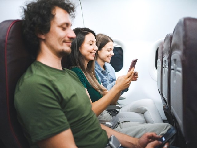 Passengers seated in airplane row