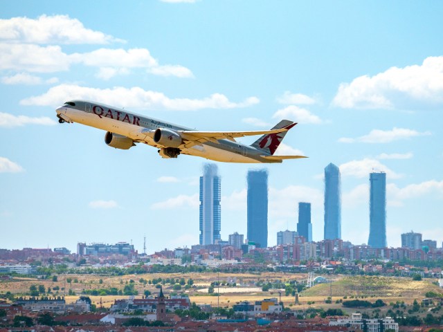 Qatar Airways Airbus A350 taking off with skyscrapers in background
