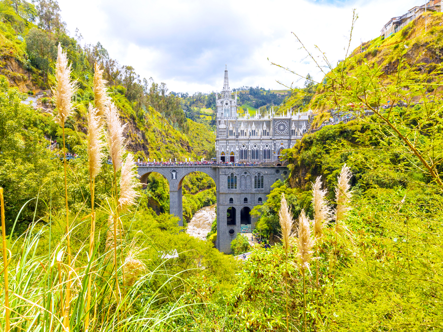 View of Las Lajas Sanctuary in Colombia beyond canyon foliage