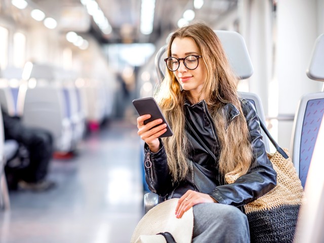 Person looking at phone while riding train