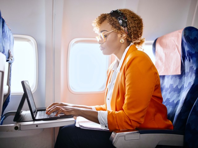 Airplane passenger using tablet on tray table