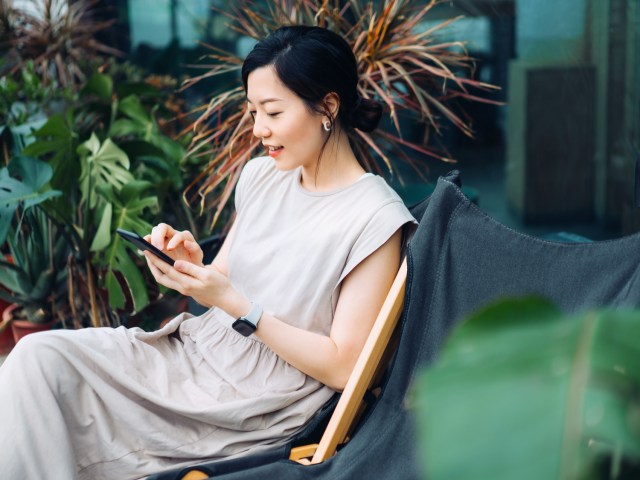 Person sitting in chair browsing on mobile phone