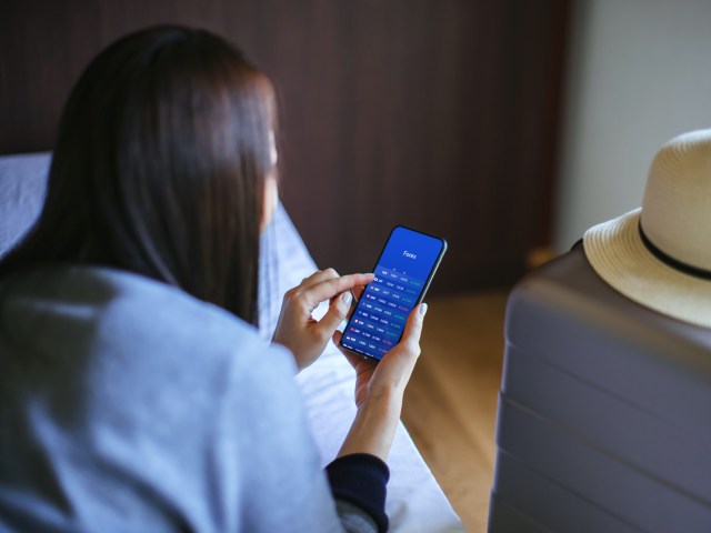 Person sitting on bed browsing phone