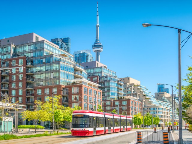 Red-and-white streetcar in Toronto, Ontario, with CN Tower looming overhead