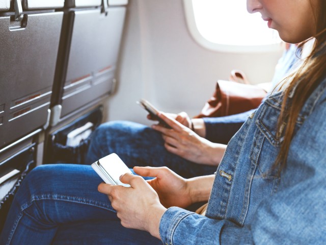 Airplane passengers browsing mobile phones