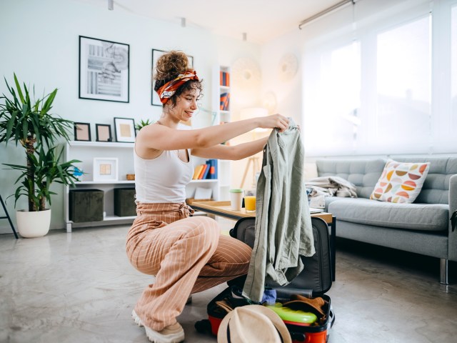Person folding clothes to pack in suitcase