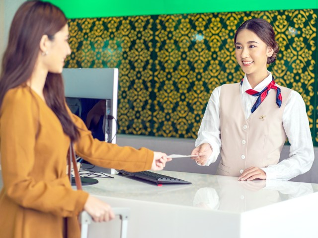Traveler interacting with hotel front desk employee