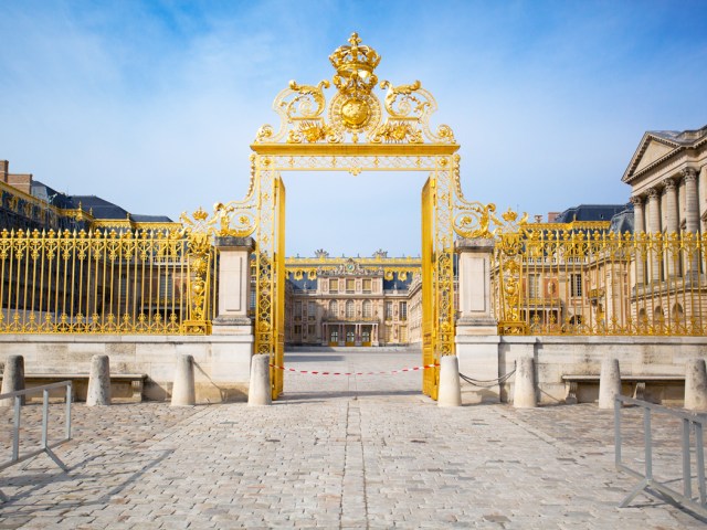 Gold-covered entrance gate to courtyard of Versailles Palace in France