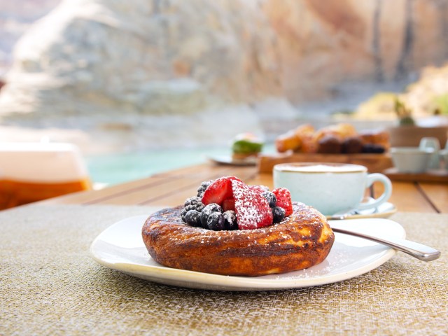 Close-up view of pancake dish with fruit at Amangiri restaurant overlooking Utah landscape in background
