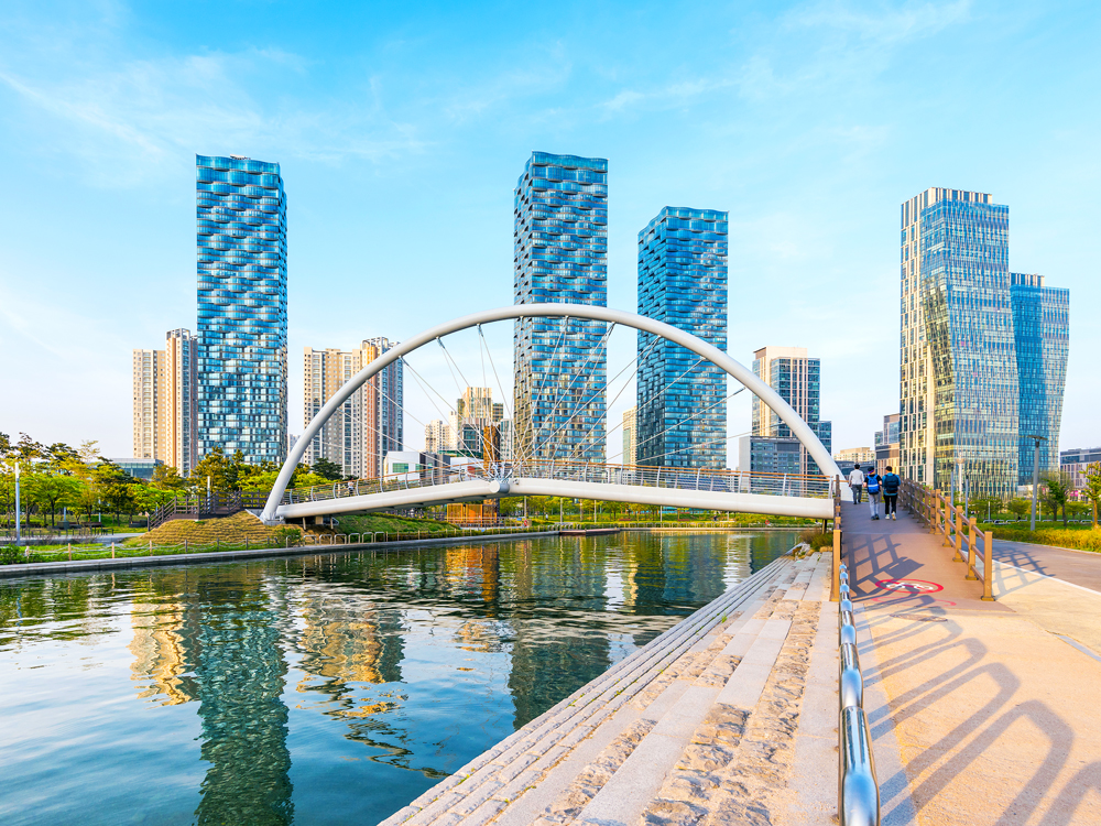 Bridge over river in Songdo, South Korea, with modern skyscrapers in background