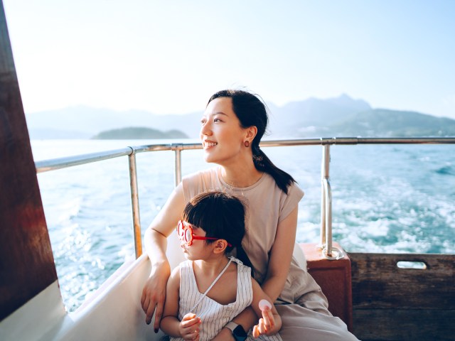 Mother and child on boat looking out to sea