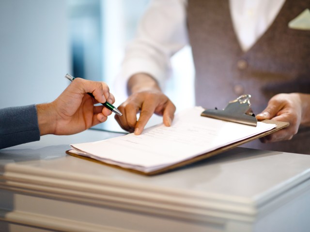 Hotel guest signing paperwork at check-in