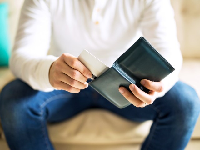 Person putting hotel key card in wallet