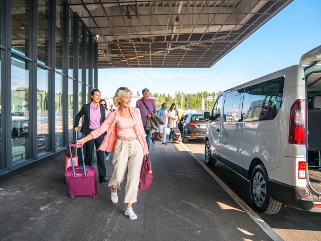 Travelers with luggage walking toward hotel shuttle