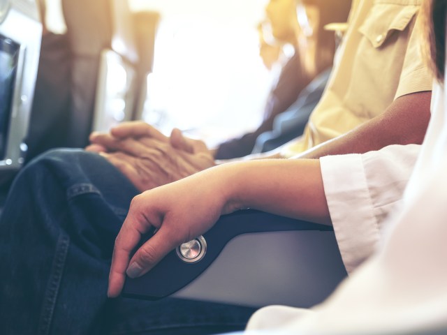 Passenger using armrest in airplane seat