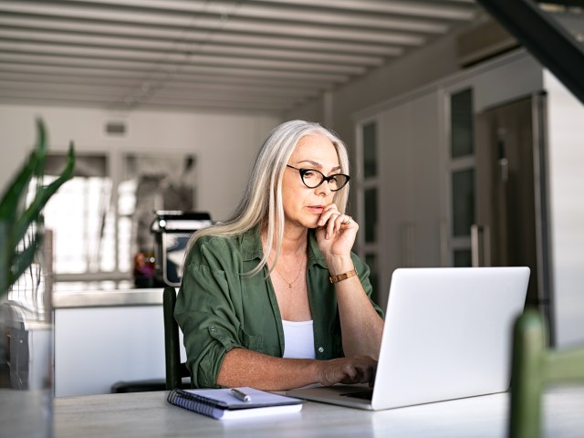 Woman sitting at desk using laptop computer