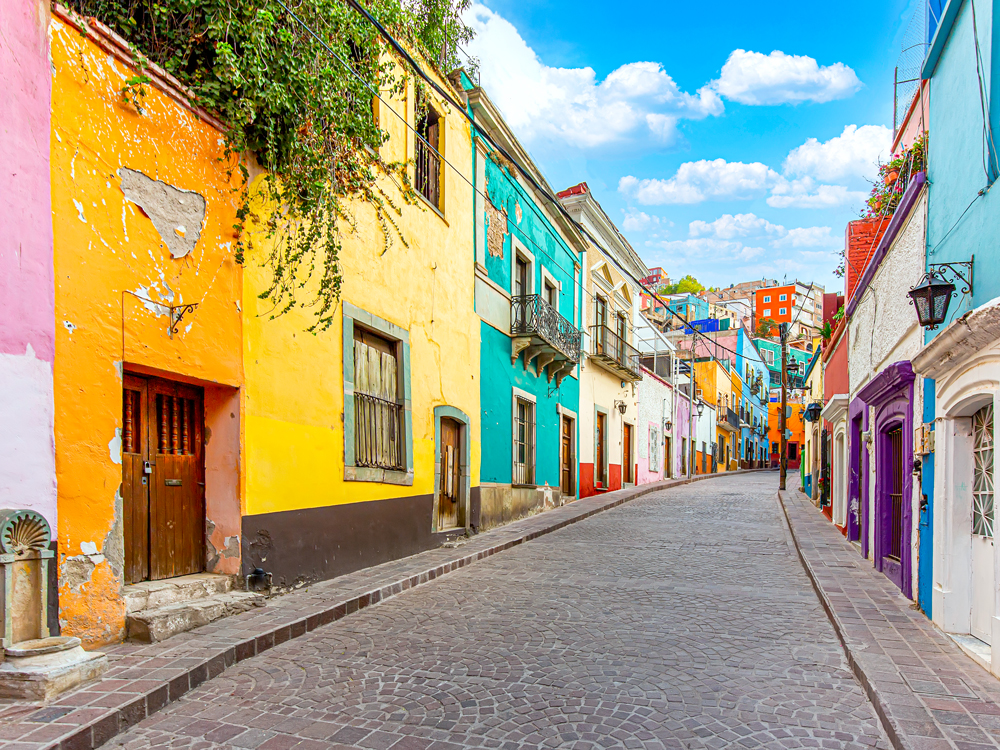 Cobblestone street lined with colorful homes in Mexico City