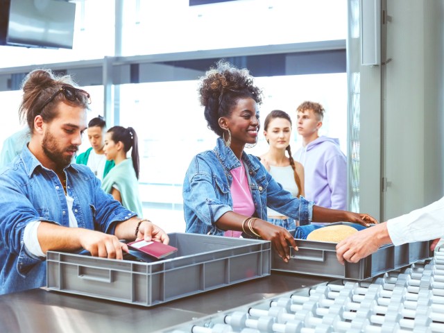 Travelers using bins at airport security checkpoint