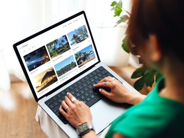 Person booking travel on laptop computer