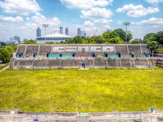 Alonzo Herndon Stadium overgrown with grass, with Atlanta skyline in background