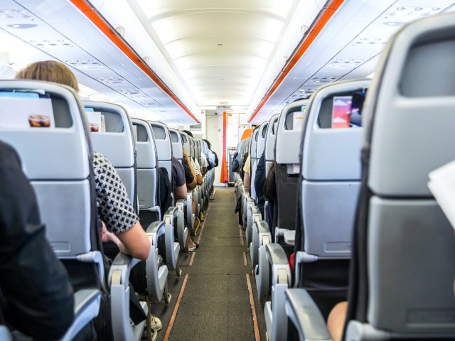 View of single-aisle aircraft cabin from back to front