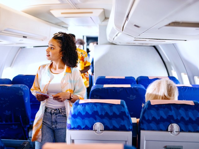 Woman standing in aircraft aisle