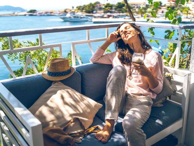 Person relaxing on outdoor sofa by the water