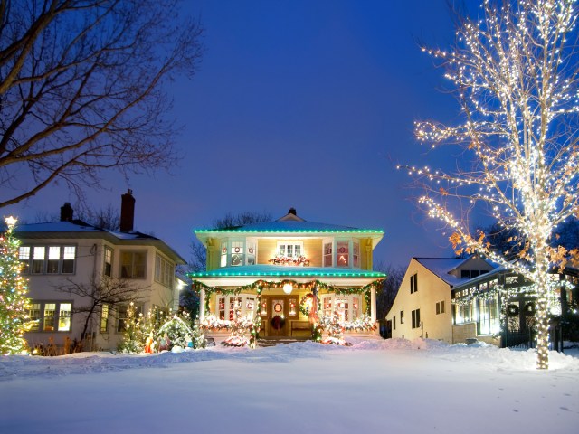 Snow-covered home decorated with holiday lights