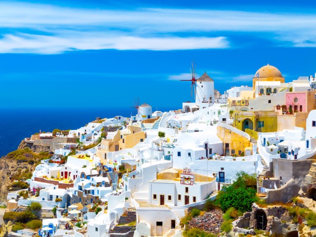 Traditional white homes on hillside overlooking Aegean Sea in Santorini, Greece