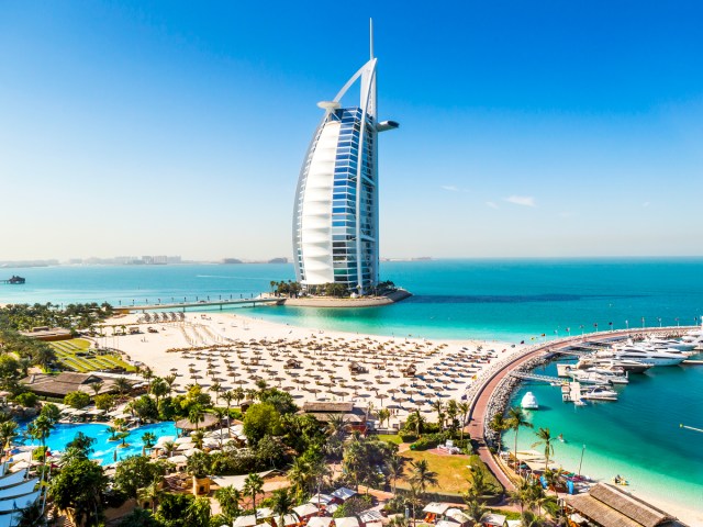 Sail-shaped Burj Al Arab Hotel towering over sandy coast of Dubai, UAE
