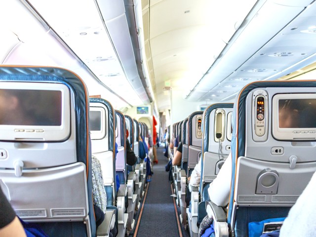 Aircraft aisle looking toward front of plane