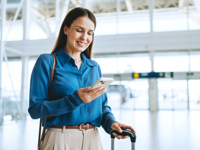 Traveler at airport using cellphone