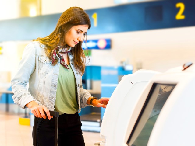 Airline passenger using check-in kiosk