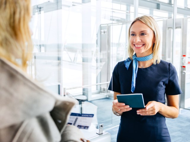 Airline passenger interacting with gate agent at airport